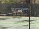 Close up of community tennis court surrounded by black fence and mature trees at 158 Weatherstone Dr, Woodstock, GA 30188
