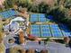 Aerial view showcasing community pickleball and tennis courts, a playground, clubhouse, and parking, surrounded by mature trees at 38 Lakeview Pt, Dallas, GA 30157
