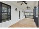 Inviting covered balcony featuring wood flooring, dark railings, and stylish exterior lighting fixtures at 727 Garibaldi Sw St, Atlanta, GA 30310