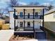 New construction home featuring a double front porch, black accents, and a manicured front lawn at 727 Garibaldi Sw St, Atlanta, GA 30310