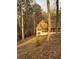 View of a cozy two-story home, surrounded by mature trees and natural landscape, bathed in sunlight at 110 Casa Domain Ct, South Fulton, GA 30349