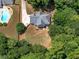 Expansive aerial view of a home with a large backyard, patio, and inviting swimming pool surrounded by lush greenery at 144 Wyckliffe Dr, Locust Grove, GA 30248