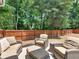 Comfortable outdoor seating and a privacy fence create an ideal relaxation area for enjoying the outdoors at 144 Wyckliffe Dr, Locust Grove, GA 30248