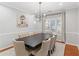 Bright dining room features modern light fixture, seating for eight, and soothing gray tones at 144 Wyckliffe Dr, Locust Grove, GA 30248