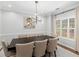 Bright dining room with modern light fixture, window, and seating for eight people at 144 Wyckliffe Dr, Locust Grove, GA 30248