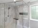 The tiled glass shower features a rainfall shower head, shower seat and inset shelves at 144 Wyckliffe Dr, Locust Grove, GA 30248