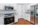 Modern kitchen showcasing stainless steel appliances, white cabinets, granite countertops, and hardwood flooring at 144 Wyckliffe Dr, Locust Grove, GA 30248