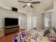 Main bedroom with a tray ceiling, ceiling fan, and a large television at 144 Wyckliffe Dr, Locust Grove, GA 30248