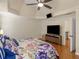 This main bedroom features hardwood floors, a tray ceiling with a ceiling fan and a large TV on the wall at 144 Wyckliffe Dr, Locust Grove, GA 30248