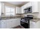 Modern kitchen featuring stainless steel appliances, white cabinets, and granite countertops at 2202 Polar Rock Sw Pl, Atlanta, GA 30315