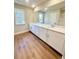 Bathroom featuring double vanity with white cabinets and hardwood floors at 2407 Malster Ln, Lawrenceville, GA 30043