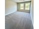 Bright bedroom with carpet flooring and lots of natural light from two windows at 2407 Malster Ln, Lawrenceville, GA 30043