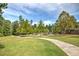 Serene community park with a paved walking path, green grass, and mature trees at 2407 Malster Ln, Lawrenceville, GA 30043