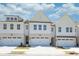 New townhome exteriors featuring white siding, brick accents, and individual one-car garages at 2407 Malster Ln, Lawrenceville, GA 30043