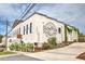 Exterior shot of Slow Pour Brewing Company, featuring white brick, logo signage, and landscaping at 2407 Malster Ln, Lawrenceville, GA 30043
