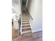 Staircase with wood treads, a light-colored runner, and a dark railing at 2407 Malster Ln, Lawrenceville, GA 30043
