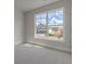 A bright bedroom featuring neutral paint, carpet, trim, and a large window with a neighborhood view at 76 Lakeview Pt, Dallas, GA 30157