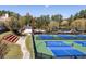 Community courts for tennis and pickleball with stadium seating and playground nearby at 76 Lakeview Pt, Dallas, GA 30157