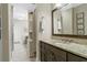 Bathroom vanity with granite countertops and dark cabinets, leading to a shower and office area at 122 Brighton Blvd, Woodstock, GA 30188