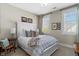 Cozy bedroom featuring plantation shutters, neutral décor, and a comfortable bed with decorative pillows and a quilt at 122 Brighton Blvd, Woodstock, GA 30188