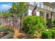 Landscaped front yard featuring lush greenery, a wooden fence, and charming garden accents at 122 Brighton Blvd, Woodstock, GA 30188