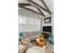 Cozy living room with stylish decor, including a gray sofa, area rug, and wooden ceiling beams, creates a welcoming ambiance at 122 Brighton Blvd, Woodstock, GA 30188