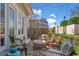 Stylish outdoor patio with comfortable seating, string lights, and a beautifully landscaped backdrop at 122 Brighton Blvd, Woodstock, GA 30188