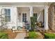 Inviting porch area with classic white columns, rocking chairs, and manicured landscaping at 122 Brighton Blvd, Woodstock, GA 30188