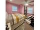 Bedroom featuring bright pink walls, a ceiling fan, and a barn door at 172 Scarsdale Dr, Riverdale, GA 30274