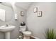 Clean powder room featuring a pedestal sink, toilet, and decorative wall art at 6336 Lake Valley Pt, Lithonia, GA 30058