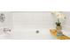 Bright bathtub with white tile surround and decorative accents at 6336 Lake Valley Pt, Lithonia, GA 30058