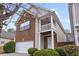 Side view showcasing brick accents, light siding, covered entryway, and manicured bushes at 6336 Lake Valley Pt, Lithonia, GA 30058