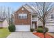 Charming two-story brick home featuring an attached garage, balcony, and well-maintained landscaping at 6336 Lake Valley Pt, Lithonia, GA 30058