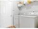 Functional laundry room with washer, dryer, storage shelf, and easy access to the door at 6336 Lake Valley Pt, Lithonia, GA 30058