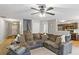 Open living room view with a large sofa, ceiling fan, kitchen and staircase at 6336 Lake Valley Pt, Lithonia, GA 30058