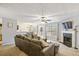 Open-concept living room featuring a plush sofa, fireplace, and dining area with natural light at 6336 Lake Valley Pt, Lithonia, GA 30058