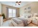 A bright staged bedroom features a large window, modern furniture, neutral decor, and ceiling fan at 3162 Abbey Sw Dr, Atlanta, GA 30331