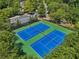 Aerial view of two tennis courts surrounded by trees and a parking lot, a clubhouse, and a neighborhood at 3162 Abbey Sw Dr, Atlanta, GA 30331
