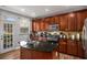 Beautiful kitchen with dark wood cabinetry, stainless steel appliances, and a center island with a sink at 509 Grove Field Ct, Suwanee, GA 30024