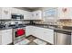 Updated kitchen with stainless steel appliances, mosaic backsplash, white cabinets and hardwood floors at 4022 Rosebud Park Dr, Snellville, GA 30039