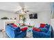 Inviting living room featuring neutral walls, fireplace, ceiling fan, and comfortable blue sofas at 4022 Rosebud Park Dr, Snellville, GA 30039