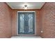 Detailed view of ornate glass and iron double front doors framed by brick facade and decorative overhead lighting at 2705 Luke Edwards Rd, Dacula, GA 30019