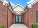 Close-up of the home's entryway showcasing the elegant glass and iron double front doors with brick facade at 2705 Luke Edwards Rd, Dacula, GA 30019