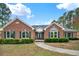 Charming brick home featuring lush landscaping, a well-manicured lawn, and a welcoming walkway to the front door at 2705 Luke Edwards Rd, Dacula, GA 30019