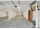 Unfinished garage with concrete floors, overhead lighting and some shelving at 2705 Luke Edwards Rd, Dacula, GA 30019