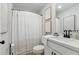 A bathroom with white cabinets, toilet, shower curtain, and framed art at 2980 Ferrington Way, Smyrna, GA 30080