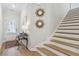 Bright foyer featuring wood floors, staircase, a console table, and access to the upper level at 2980 Ferrington Way, Smyrna, GA 30080