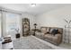 A cozy living room with a leather couch, carpet, and a window with blinds at 2980 Ferrington Way, Smyrna, GA 30080