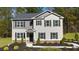 Charming two-story home with a landscaped front yard, black shutters and a black front door at 221 Friendship Oak Way, Hampton, GA 30228
