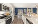 Open concept kitchen with white cabinets, granite countertops, stainless steel appliances and an island at 221 Friendship Oak Way, Hampton, GA 30228